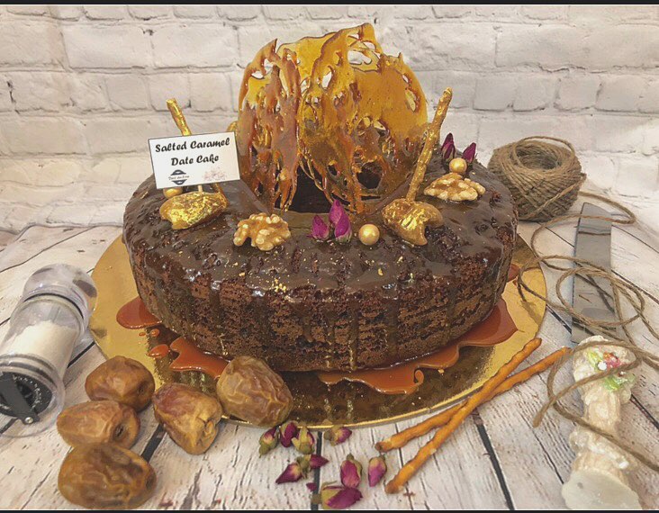 . . Our signature cake . Salted caramel date cake stuffed with crunchy walnuts and covered