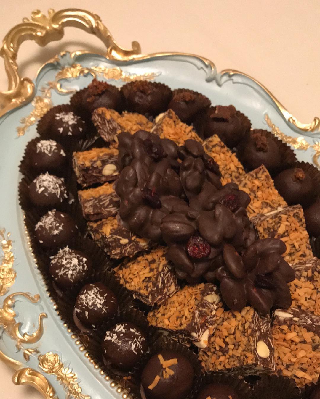 صينية منوعة تحتوي على كرات التمر وكرات جوز الهند وكرات جوز الهند المبشور مع زبدة الفول الس