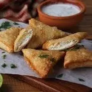 سمبوسة "الأجبان الفاخرة".. قرمشة من الخارج، ونعومة تذوب في الداخل! 🧀✨ لمحبي اللمسة المخملية والنكهة الغنية، نقدم لكم سمبوسة الجبن المحضرة بعناية فائقة. لقد صهرنا خبرتنا الطويلة لنقدم لكم قطعة ذهبية تتناغم فيها ملوحة الأجبان المختارة مع قرمشة العجين الرقيق. ✨ ما الذي يميز سمبوسة الجبن لدينا؟ مزيج الأجبان الملكي: نستخدم خليطاً خاصاً من الأجبان الكريمية والمالحة التي تذوب بانسيابية عند أول قضمة، لتمنحكم طعماً غنياً ومتوازناً. العجينة الهشة: طبقات رقيقة جداً ومقرمشة، مطهوة لتكون خفيفة وذهبية دون أن تثقلها الزيوت، مما يجعلها رفيقاً مثالياً لكل الأوقات. إتقان اللف اليدوي: كما يظهر في صورنا، كل حبة مغلقة بإحكام وبشكل هندسي مرتب، لضمان بقاء الحشوة بداخلها وتحقيق أجمل تقديم على مائدتكم. زينة الضيافة: نقدمها لكم مع الليمون المنعش والأعشاب الطازجة، لتعطي شكلاً يفتح الشهية ويبيض الوجه أمام ضيوفكم. لماذا تطلبين من مطبخنا الخبير؟ خبرة الـ 7 سنوات: نطبق نفس دقة "كيكات الماربل" في ضبط حرارة القلي ووقت التحضير لضمان جودة ثابتة في كل حبة. نظافة منزلية فائقة: نعتني بأدق تفاصيل التحضير اليدوي لنقدم لكم غذاءً آمناً ولذيذاً