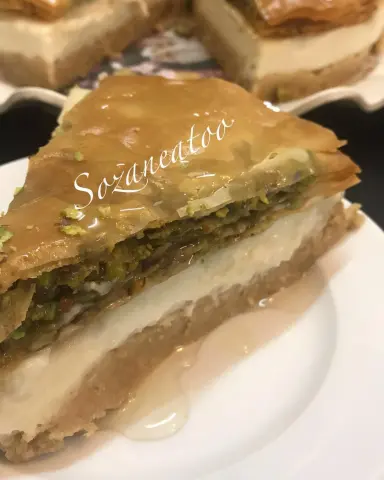 باسم الله وطبقنا الطريقه ولله الحمد نالت اعجاب الجميع وعليكم بالعافيه ماأرجوه دعوه في ظهر الغيب والطريقه سهله وهي طبقه من عش السرايا وعليها طبقة البقلاوه بالفستق وهي عباره عن ثلاث طبقات ١:كيس توست مفروم ناعم ونجيب التشريبه وهي نص ك سكر على النار لين يشقر ثم نصب ٢ك ماء فاتر ثم نظيف نص سكر عادي ورشة ملح اليمون لين يذوب السكر ممكن نحط موية ورد على حسب الرغبه ونصبه على الخبز المفتت ونرصه بصينه متحركه ثم نجهز خليط عش السرايا ٢:عباره عن ليتر حليب بالقدر مع نصف ك نشاء ونصف ك دقيق و١ك سكر ونحرك لين يثقل الخليط ثم نظيف علبة قشطه وم ص ماء ورد وزهر ونحرك لين يتجانس ثم اصبها على طبقة التوست الاولى ثم بثلاجه اخليها فوق ال٤ساعات ولو يوم كامل ألذ ثم اجهز الطبقه ٣:وهي عباره عن جلاش ٨طبقات قصيناهاعلى مقاس الصينيه ثم بصينية احط طبقتين ثم امسح زبده وارش عليها سكر ناعم ثم أرش فستق ثم أضع طبقتين وأمسح بالزبده وأرش كذالك على هالطريقه لين تخلص الكميه واخر شيء امسح بزبده ثم اقطعها ثم بالفرن ١٥د لين تحمر وأصب عليها شيره وهي حاره الجلاش ثم اضعهاعلى عش السرايا وأزينه بالكريمه وحبة كرز او اي شيء تحبونه وهني وعافيه #حلويات_الرياض #سوزانيتوو_حلويات_مميزه_مفيده #تطبيق_حلويات #ماشاء_الله #دعمكم_لي_يساعدني_على_الاستمرار #دعم_الاسر_المنتجة #دعم_المشاريع_الصغيرة #دعم_متاجر #دعم_سناب #دعم_حساب #نشر_سناب #نشر_حساب #نشر_للكل #نشر_حسابات_انستجرام