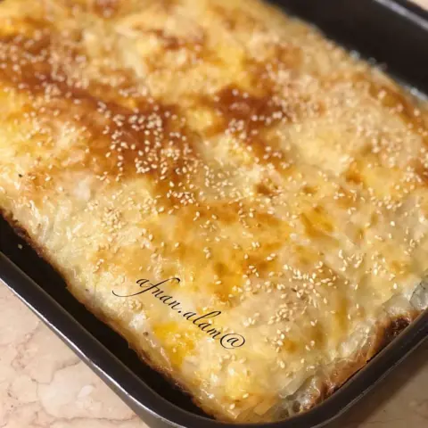 بوريك تركي بالجبنة علبة عجينة جلاش جاهزة نص كيلو جبنة بيضاءهنغاري مبشورة او اي نوع ٢ م/ك نعناع مجفف@afnan.alam في زبديه نص كوب لبن + نص كوب زيت + رشة ملح صفار بيضة لدهن الوجه شوية سمسم للزينه الطريقه@afnan.alam -في صينيه مدهونة بشوية زيت اضع اثنين من الرقاق ثم بالملعقه اضيف من خليط اللبن وادهنه بالفرشة ثم اوزع الجبنة كمية قليله بشكل عشوائي@afnan.alam -ثم اضع واحد من الرقاق وادهن خليط اللبن واوزع الجبنة بنفس الكمية القليله ثم اضع واحد من الرقاق فوقه واكرر نفس الخطوات@afnan.alam -اخر طبقة ادهنها صفار بيض وارش سمسم -ادخلها الفرن على درجة حرارة ٢٠٠ ( فرني غاز ) احمرها اولاً من تحت ثم احمرها من فوق وبعد تتحمر اتركها ترتاح شوية لمدة ٦-٧ دقائق ثم اقطعها مربعات وبالعافيه@afnan.alam #افنان_العالم_وصفات